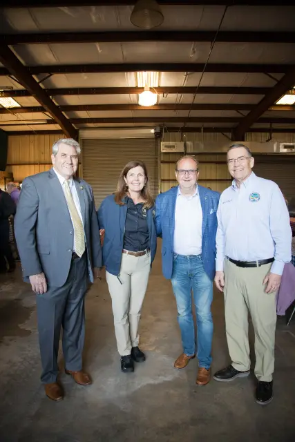 Four guests pose together on the hall floor
