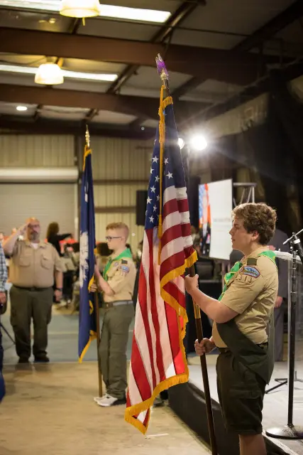 A Scout holds the American flag during the presentation of colors